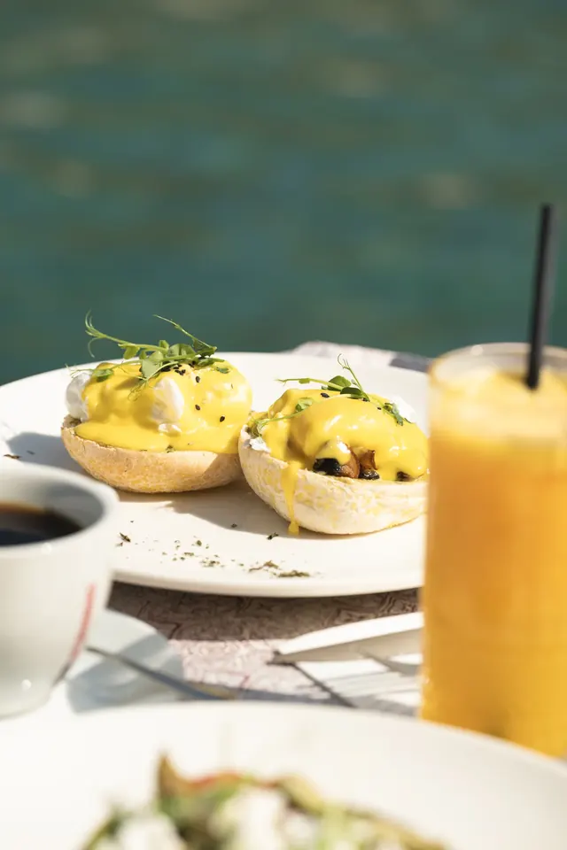 Eggs Benedict and orange juice in the sunshine